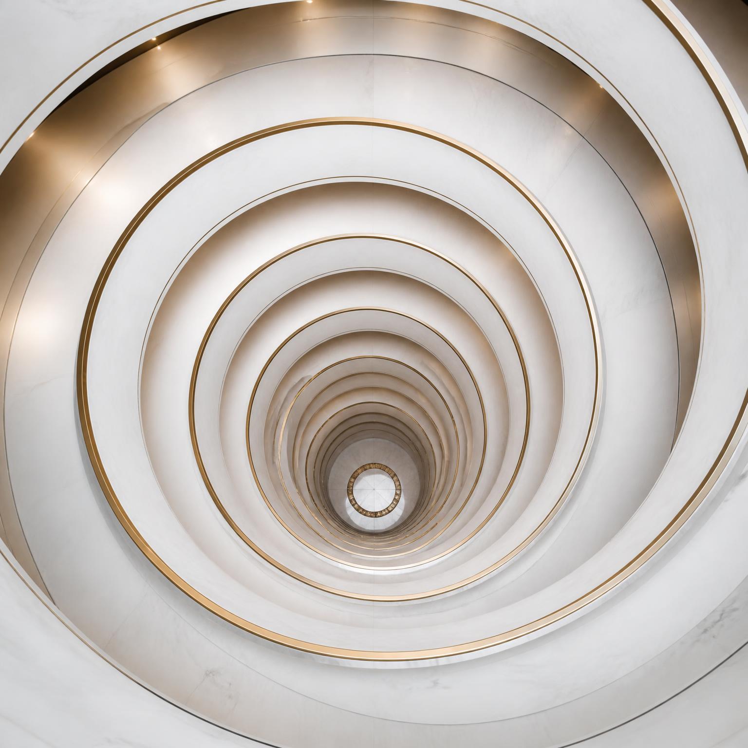 Descending white spiral staircase seen from above